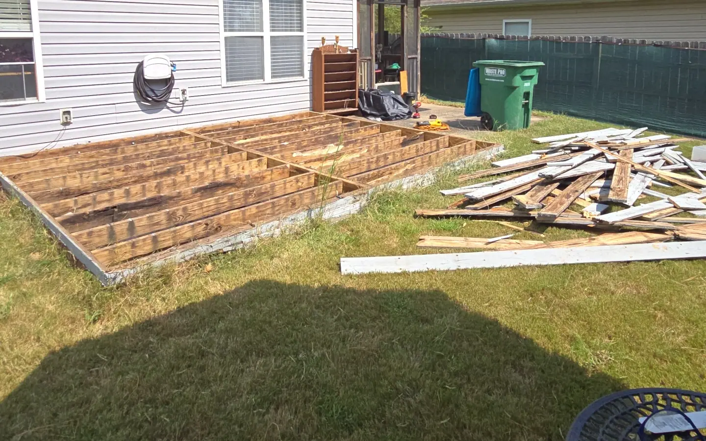 A backyard deck torn up board by board during a Racoons deck removal