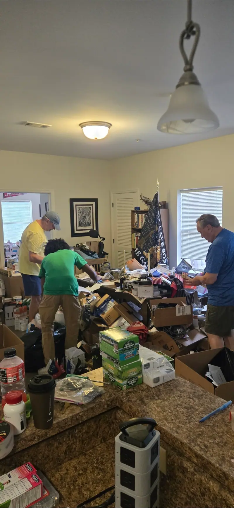 The Racoons crew working through a crowded kitchen during a cleanout